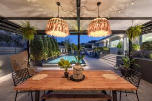 a patio with a wooden table and chandeliers at Solena Villa in Stavromenos