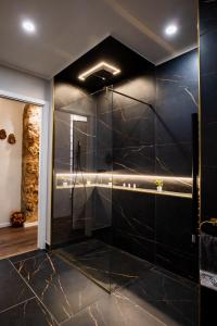 a bathroom with a shower with black tiles at B&B er in Isola del Liri +47 photos