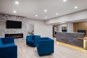 a lobby with blue chairs and a fireplace at Baymont by Wyndham Mankato in Mankato