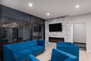 a living room with a blue couch and a fireplace at Baymont by Wyndham Mankato in Mankato