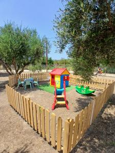 a small playground with a play set in a fence at Three Charites Resort in Gialova
