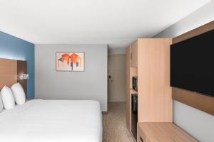 a bedroom with a bed and a flat screen tv at Baymont by Wyndham Mankato in Mankato