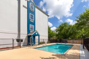 a swimming pool in front of a building with a church at Microtel Inn and Suites Baton Rouge Airport in Baton Rouge