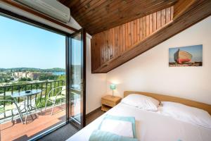 a bedroom with a bed and a large window at Guest House Villa Bellevue in Cavtat