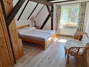 a bedroom with a bed and a chair at Powrócisz tu... in Sorkwity