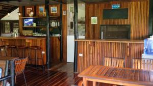 a restaurant with a table and chairs and a bar at Binga Beach Resort in San Miguel