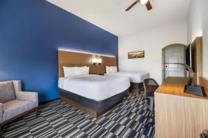 a hotel room with two beds and a chair at La Quinta by Wyndham Alvin in Alvin +37 photos