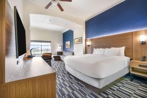 a hotel room with a large bed and a television at La Quinta by Wyndham Alvin in Alvin