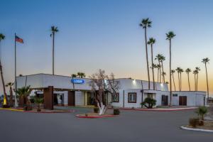 a mobil gas station with palm trees in the background at Travelodge by Wyndham Imperial - El Centro in El Centro