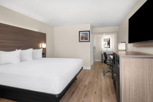 a hotel room with a large bed and a desk at Travelodge by Wyndham Imperial - El Centro in El Centro