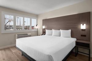 a bedroom with a large white bed and a window at Travelodge by Wyndham Imperial - El Centro in El Centro +56 photos