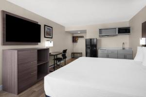 a hotel room with a bed and a flat screen tv at Travelodge by Wyndham Imperial - El Centro in El Centro