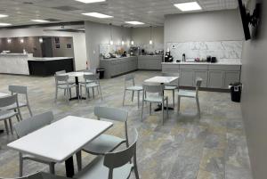 a cafeteria with tables and chairs and a kitchen at Ramada by Wyndham Cobleskill in Cobleskill +17 photos
