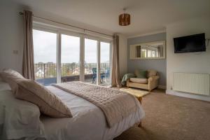 a bedroom with a bed and a large window at Croft House in Croyde