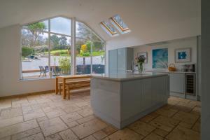 a large kitchen with a large window and a table at Croft House in Croyde
