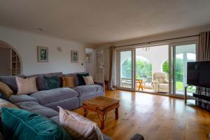 a living room with a couch and a table at Croft House in Croyde