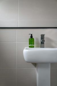 a green soap bottle sitting on a sink in a bathroom at Croft House in Croyde +51 photos