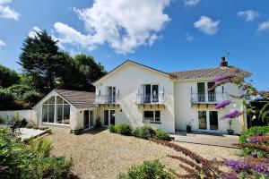 a white house with a balcony and a yard at Croft House in Croyde