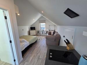 a bedroom with a bed and a living room at Great Warm Studio Unit in Queenstown Airport