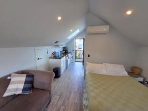 a living room with a bed and a couch at Great Warm Studio Unit in Queenstown Airport