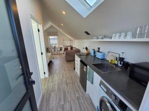 a kitchen with a counter top and a living room at Great Warm Studio Unit in Queenstown Airport