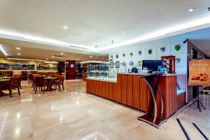 a restaurant with a bar and tables and chairs at THE 1O1 Malang OJ in Malang +42 photos
