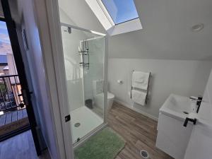 a bathroom with a shower and a toilet and a sink at Great Warm Studio Unit in Queenstown Airport