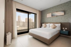 a bedroom with a large bed and a large window at Tranquil Wellness Tower By Wellcube in Dubai +79 photos