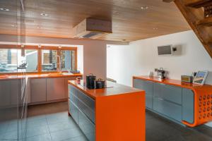 a kitchen with orange and blue cabinets and a counter at Croyde Barn in Croyde