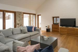 a living room with a couch and a flat screen tv at Croyde Barn in Croyde