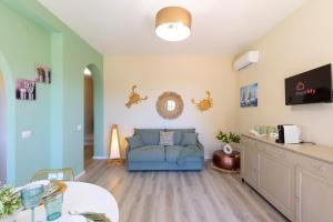 a living room with a blue couch and a table at Sea Breeze - Mare a 50mt & Terrazza Relax in Quartu SantʼElena