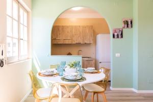 a kitchen with a table and chairs and an archway at Sea Breeze - Mare a 50mt & Terrazza Relax in Quartu SantʼElena