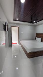 a bedroom with a large bed with a wooden headboard at Abidharpp in Velankanni +11 photos