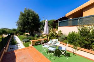 a patio with an umbrella and a table and chairs at Sea Breeze - Mare a 50mt & Terrazza Relax in Quartu SantʼElena