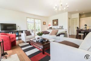a living room with white couches and a table at Villa les paradoux in Pin-Balma