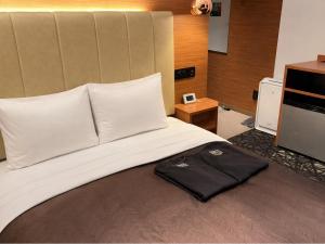 a bed with a black bag sitting on top of it at Place Hotel Ascot in Kumamoto +89 photos