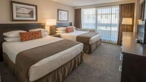 a hotel room with two beds and a television at The Embassy Inn in Victoria