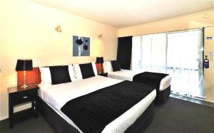 En eller flere senger på et rom på Accolade Lodge Motel