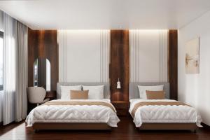 two beds in a large room with wooden walls at Thùy Dung 68 Hotel in Dong Hoi