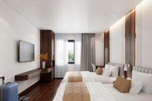 a hotel room with two beds and a television at Thùy Dung 68 Hotel in Dong Hoi