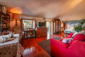 a living room with a red couch and a bed at Mansarda Vista Mare Nel Verde in Quercianella