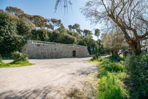 a stone wall next to a dirt road at Mansarda Vista Mare Nel Verde in Quercianella
