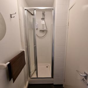 a shower with a glass door in a bathroom at Fadrun Cottage in Llangian