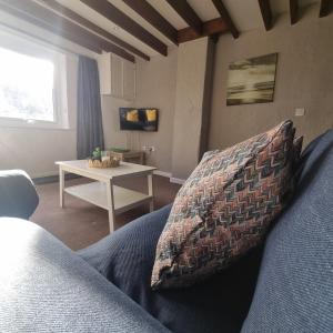 a living room with a blue couch and a table at Fadrun Cottage in Llangian
