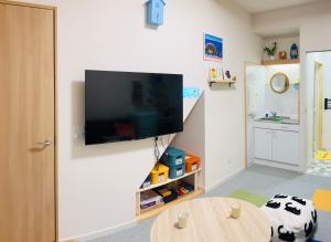 a living room with a flat screen tv on a wall at 旅の宿 もはち Private Guesthouse MOHACHI in Tsuruoka