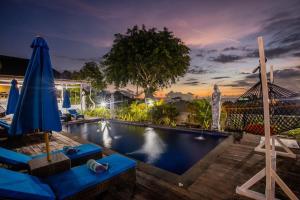 a pool at a resort with blue chairs and an umbrella at Tatak Bunut Villa Ceningan in Nusa Lembongan