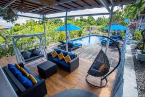 a patio with blue furniture and a swimming pool at Tatak Bunut Villa Ceningan in Nusa Lembongan