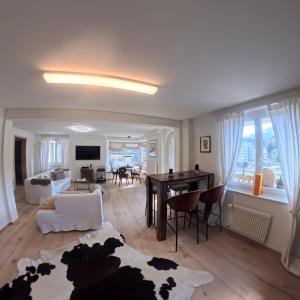 a living room with a table and a couch at 5 room apartment for 8 people at Bergcafe Aurora Lenzerheide in Lenzerheide