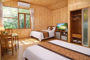 a hotel room with two beds and a television at Midtown homestay in Phong Nha