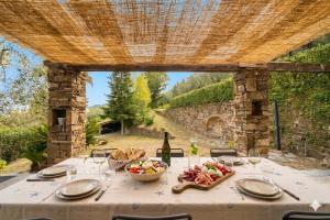 a table with a bowl of food and a bottle of wine at Casa Liselotte in Imperia